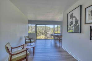 A spacious room with a large window, a dining table, and two chairs.