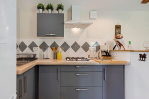 Una cocina moderna con armarios grises, una estufa a gas y un microondas.