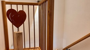 Una scala in legno con decorazione a forma di cuore sulla ringhiera.