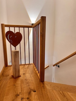 Eine Holztreppe mit einer herzförmigen Dekoration an der Geländer.