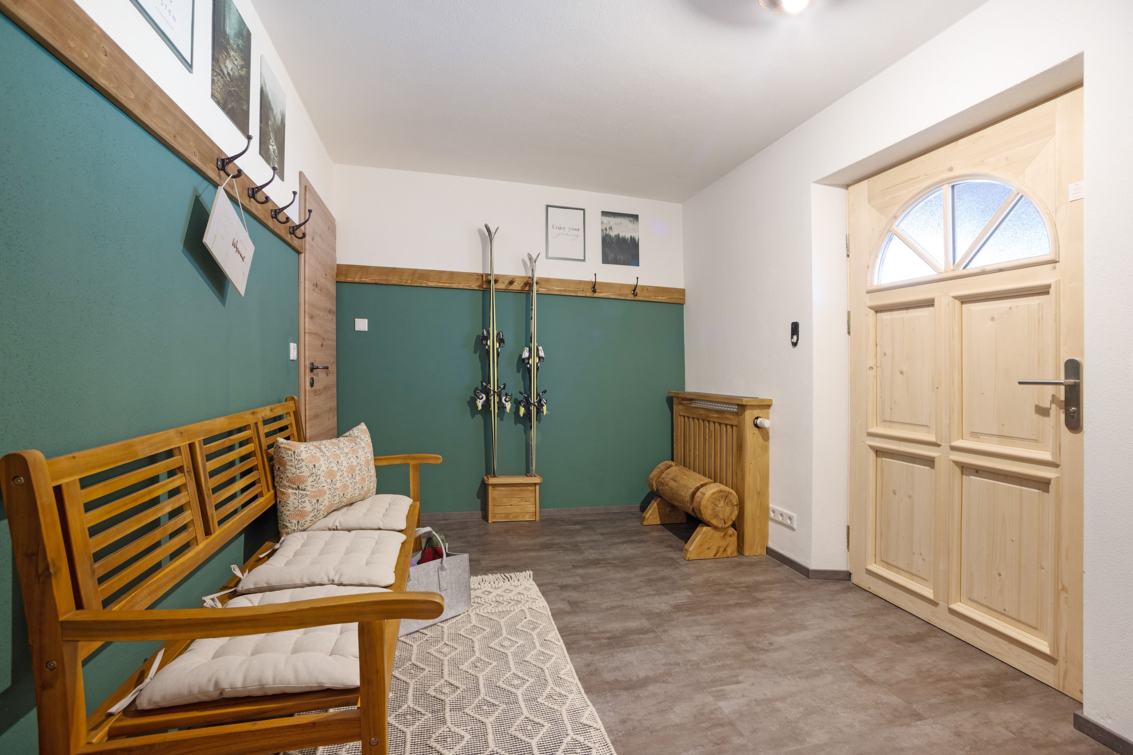 A room with a wooden bench, a small table, and a door with a window.