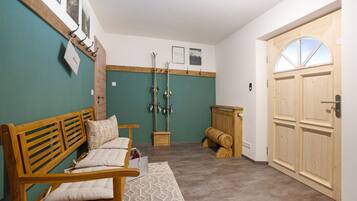 A room with a wooden bench, a small table, and a door with a window.