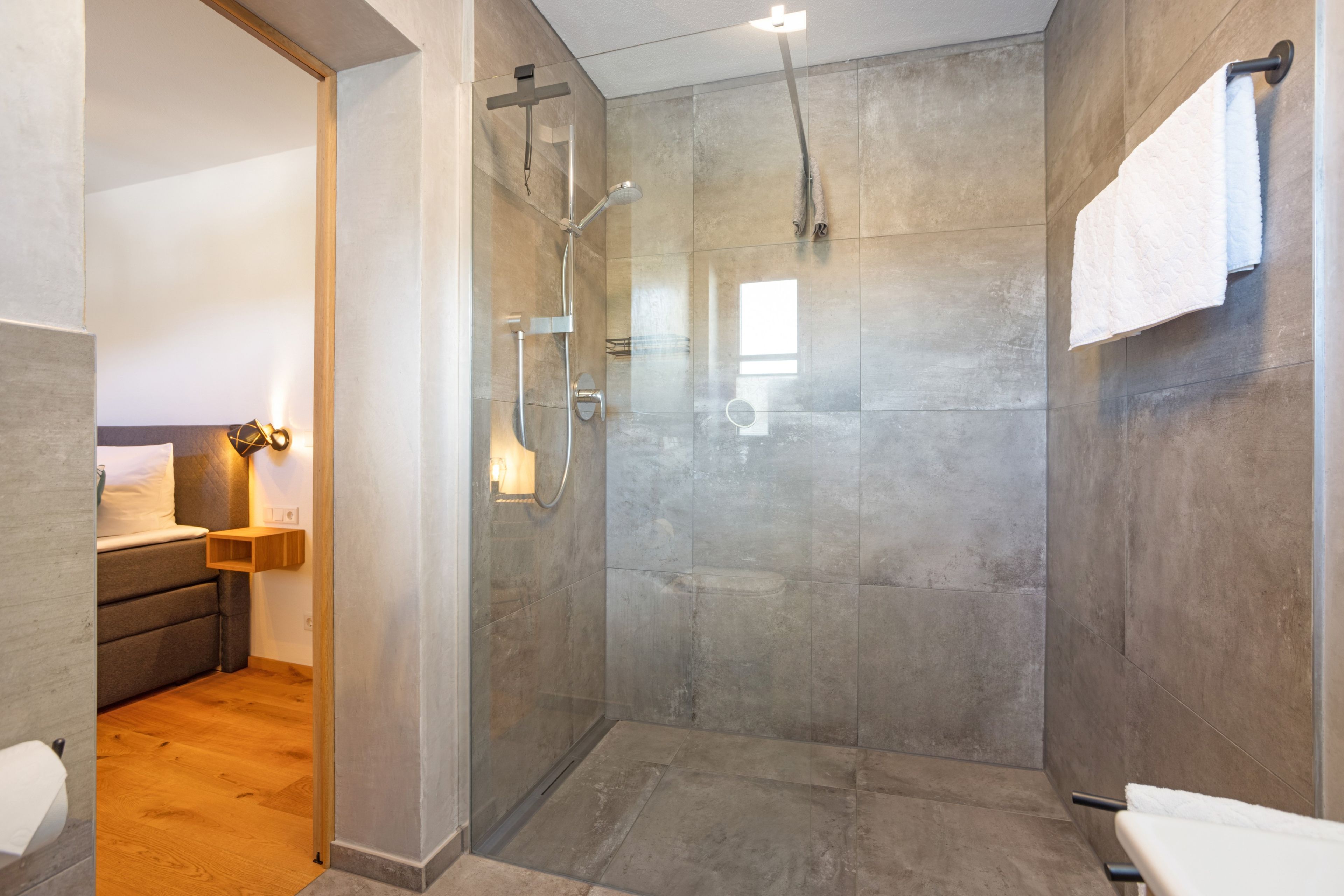 Ein modernes Badezimmer mit einer Glasdusche, einer Toilette und einem Waschbecken.