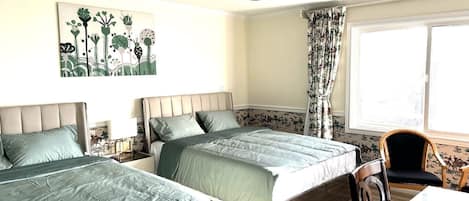 Une chambre avec deux lits, une table et une chaise.