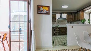 A modern kitchen with a dining area, a sliding glass door leading to an outdoor patio, and a patterned floor.