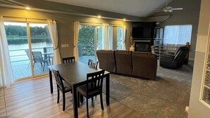A spacious living area with a dining table, sofas, and a ceiling fan. - Beautiful lakefront home on beautiful Crooked Lake (Angola)