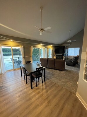 A spacious living area with a dining table, sofas, and a ceiling fan. - Beautiful lakefront home on beautiful Crooked Lake (Angola)