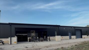 A large industrial building with multiple garage doors and a chimney.