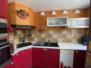 A kitchen with red cabinets, a microwave, and a coffee maker.