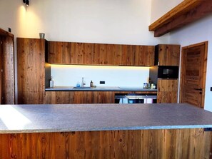 Una cuina moderna amb armaris de fusta i una illa central.