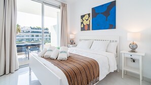 Een hotelkamer met een bed, nachtkastje, lamp en kunst aan de muur.