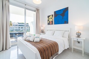 A hotel room with a bed, a nightstand, a lamp, and artwork on the wall. - Cubo's Bel-Air Estepona Apartment / communal pool / parking included / air conditioning / free Wi-Fi (Estepona)
