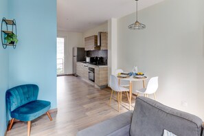 A modern apartment with a kitchen, dining area, and seating. - Le Cocon Bleu - Bel appt pour 6 en centre-ville (Montlucon)
