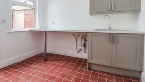 Una cocina con ventana, un lavamanos y armarios.