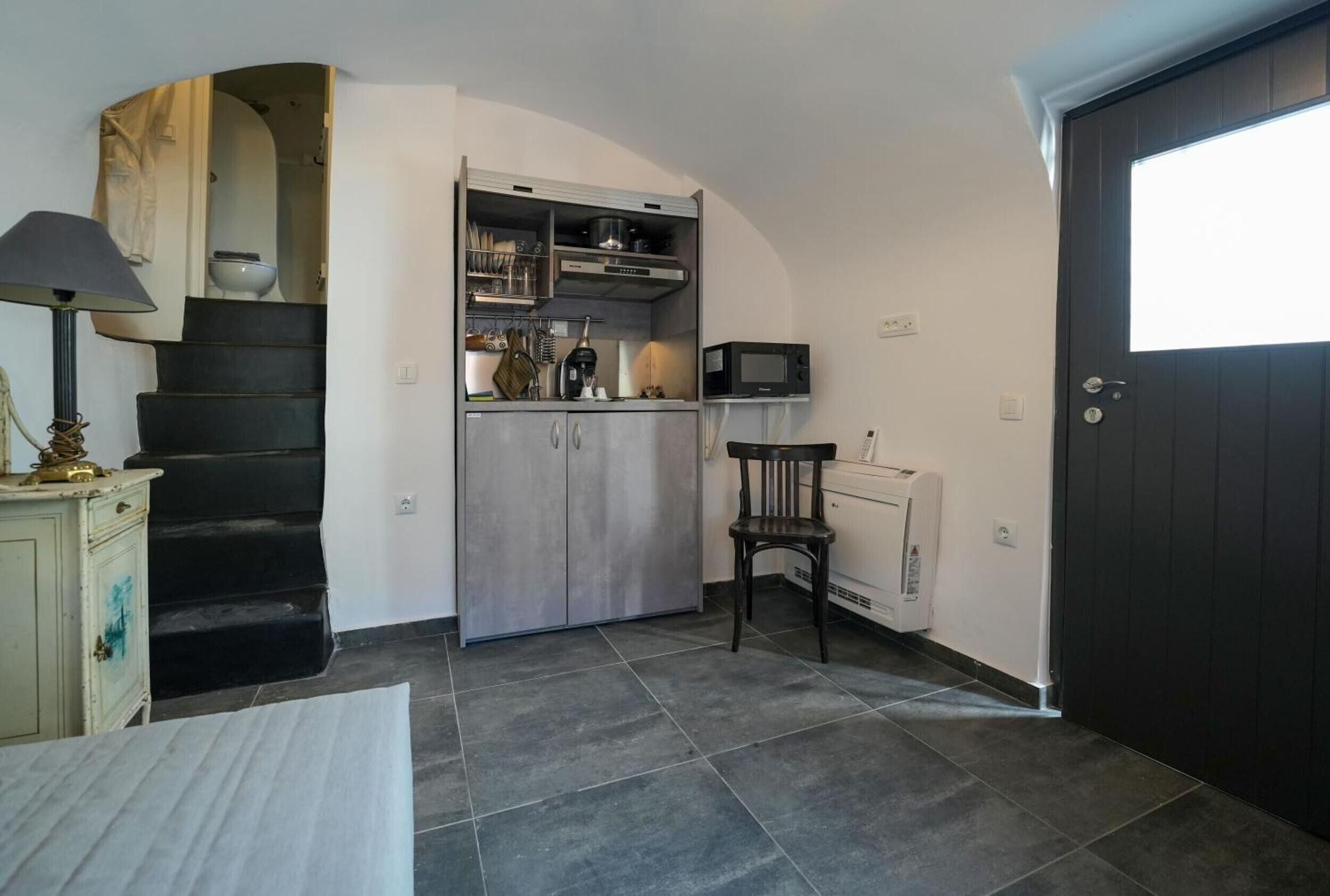 A compact kitchen with a built-in stove, microwave, and storage cabinets.