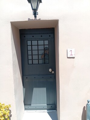 A black door with a grid pattern, a keyhole, and a small number sign on the wall beside it. - Apartment 'Studio' with Wi-Fi and Air Conditioning (Emporio)