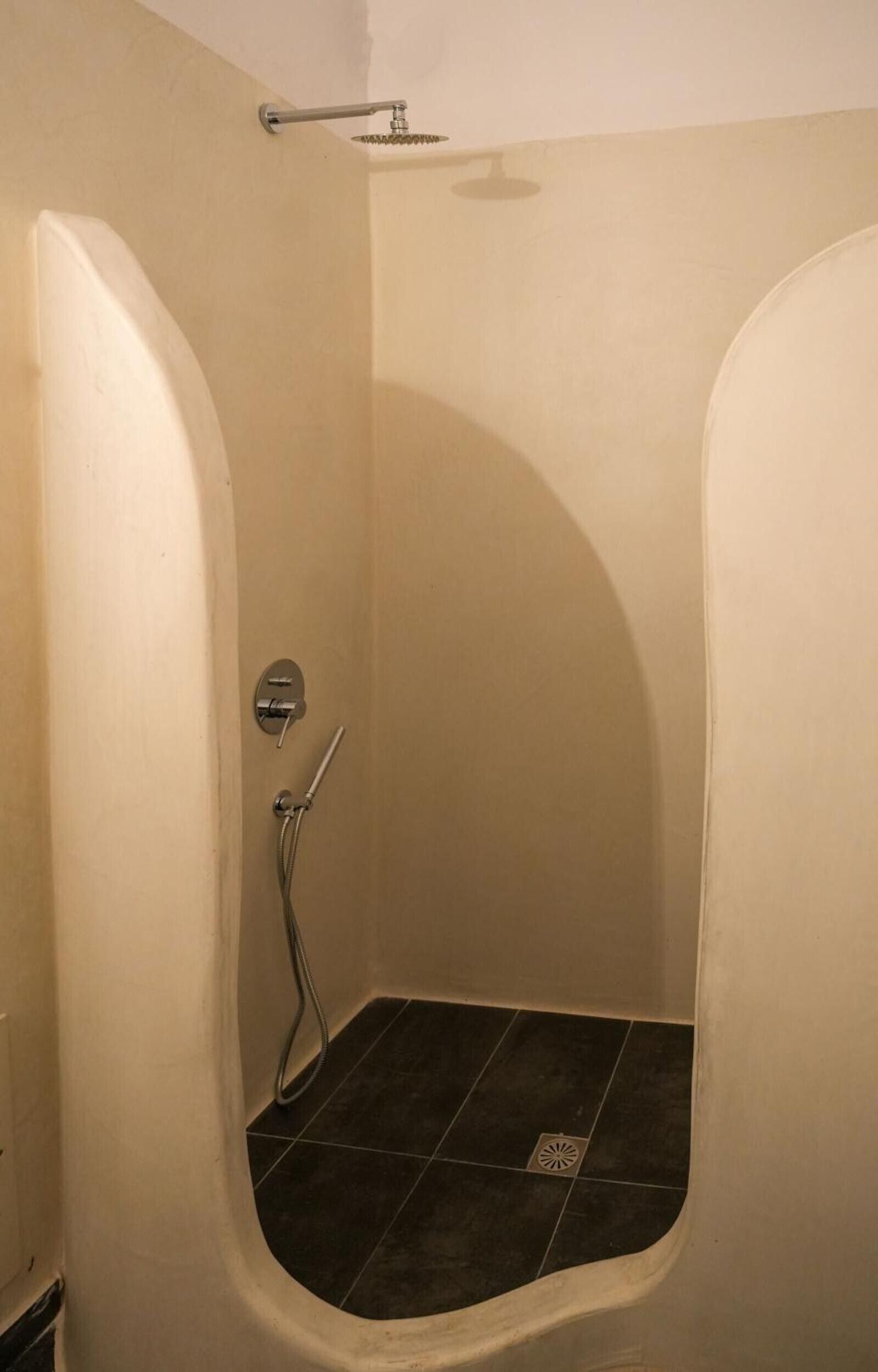Eine Duschkabine mit Handbrause und Handtucharmatur.