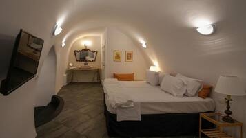 Ein Schlafzimmer mit einem Bett, einem Schreibtisch und einem Spiegel.