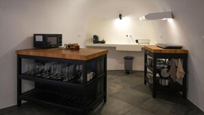 Une cuisine compacte équipée d’un four à micro-ondes, d’un évier et d’un petit coin repas avec une table et des chaises.