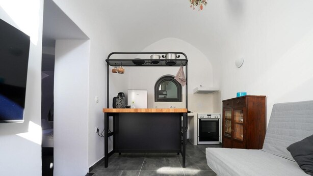 A compact kitchen with a built-in oven, a small refrigerator, and a wooden countertop. - Apartment 'One-Bedroom' with Wi-Fi and Air Conditioning (Emporio)