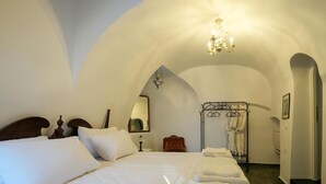 A bedroom with a large bed, a nightstand, a hanging light fixture, and a walk-in closet with hanging clothes. - Apartment 'One-Bedroom' with Wi-Fi and Air Conditioning (Emporio)