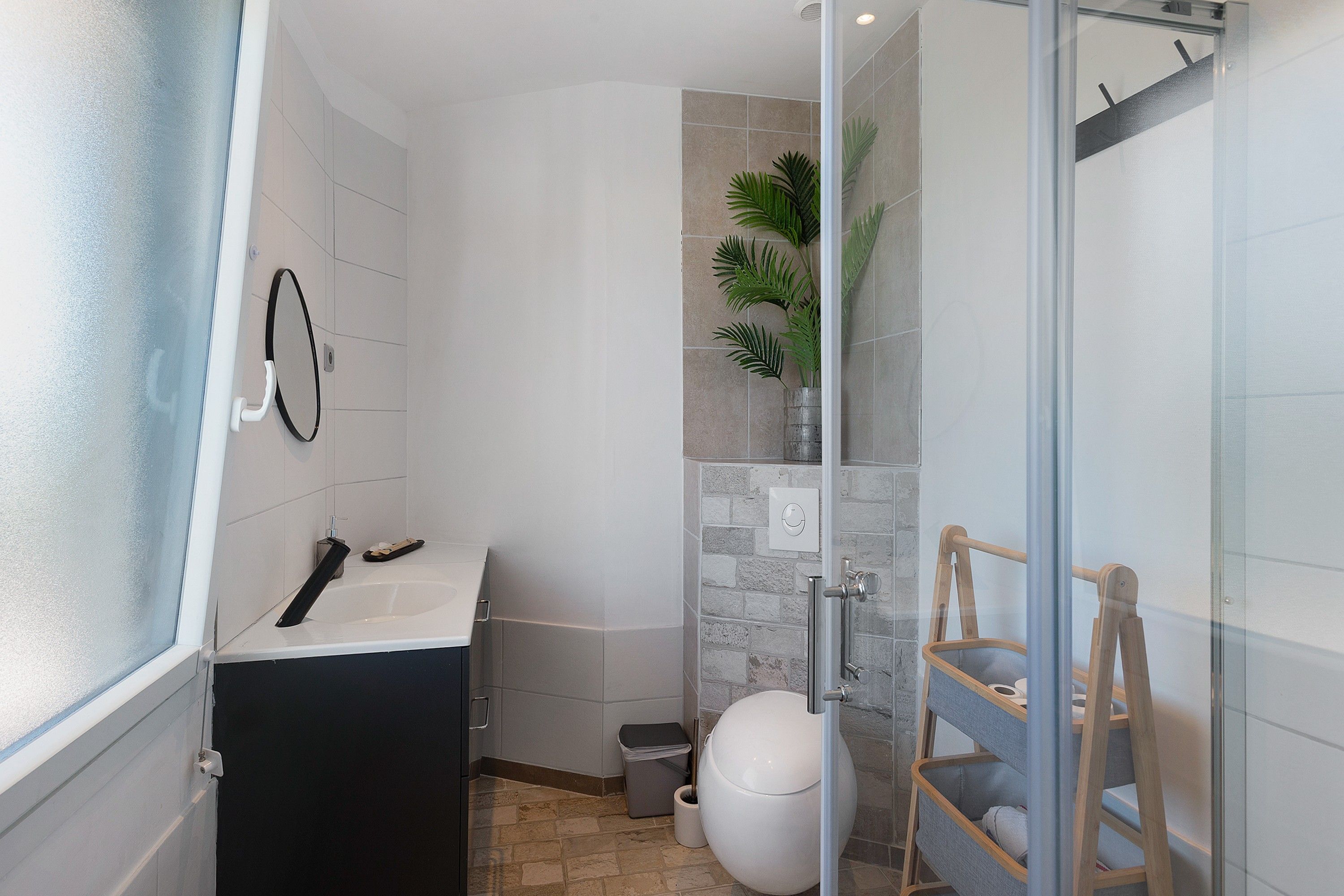 Een badkamer met douche, toilet en wastafel.