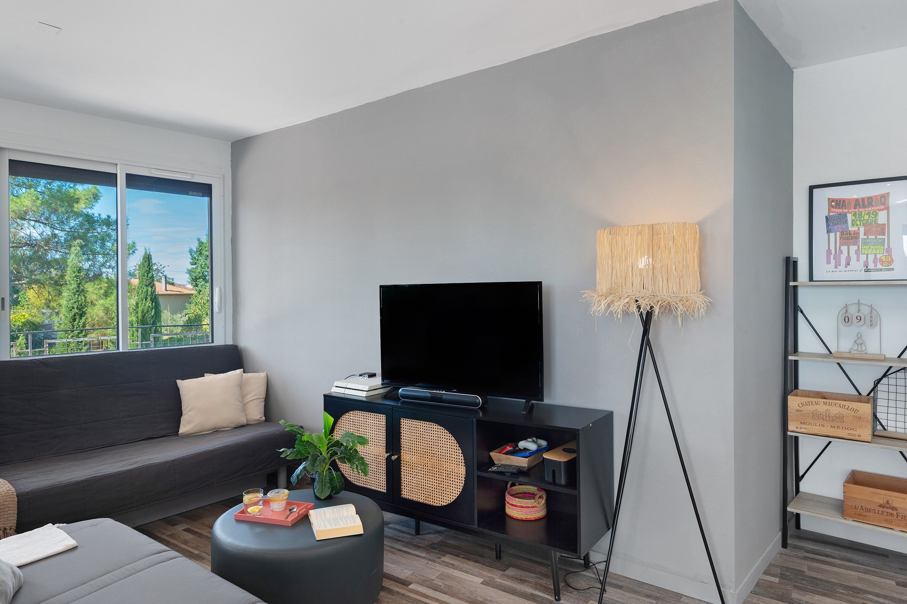 Uma sala de estar moderna com sofá, mesa de centro, TV e estante de livros.