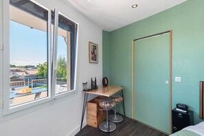 A room with a desk, two chairs, a window, and a door.