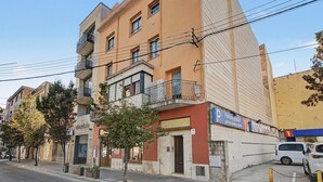 Um edifício com vários andares, que inclui uma loja no térreo e uma área de estacionamento.