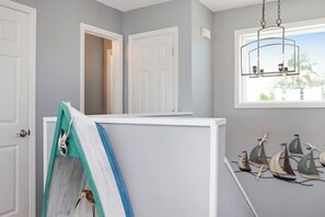 A room with a white door, a white partition, a window with a view, and a wall-mounted light fixture. - Private Pool | Beachfront Decks | Walk to Beach | Cottage By The Sea (St. Joe Beach)
