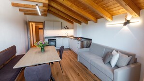 A modern kitchen with white cabinets and a wooden ceiling. - Holiday Apartment 'Am Oberranhof' with Mountain View, Shared Terrace, and Wi-Fi (Deutschnofen)