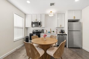 A compact kitchen with white cabinetry, a microwave, stove, and a refrigerator. - 6 Bedrooms Perfect for Large Groups (Lafayette)