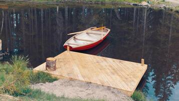 Un muelle de madera que se extiende sobre una masa de agua tranquila, con un pequeño bote amarrado al final.