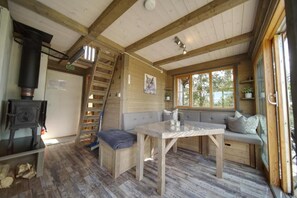 A cozy cabin interior with a wooden staircase, a table, and a bench.
