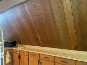 Ein Zimmer mit Holzboden, einer Küchenarbeitsplatte und Holzschränken.