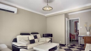 Ein Wohnzimmer mit einer Couch, einem Couchtisch und einem Essbereich mit Stühlen und einem Tisch.