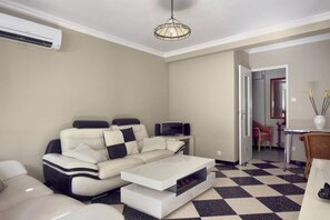 Un salon comprenant un canapé, une table basse et un coin repas avec des chaises et une table.