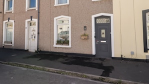 A row of terraced houses with white-framed windows and doors, some with shutters, and a small garden box on the right side. - 18 Kent Street (Cardiff)