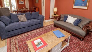 A living room with two sofas, a coffee table, and a patterned rug. - 18 Kent Street (Cardiff)