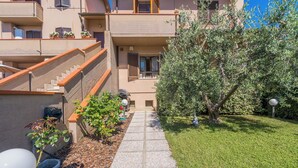 A residential building with a paved pathway leading to the entrance, surrounded by greenery and a well-maintained lawn. - Casa Vellaria – Charming Home with Garden in Tuscany near Pisa & Florence (Forcoli)