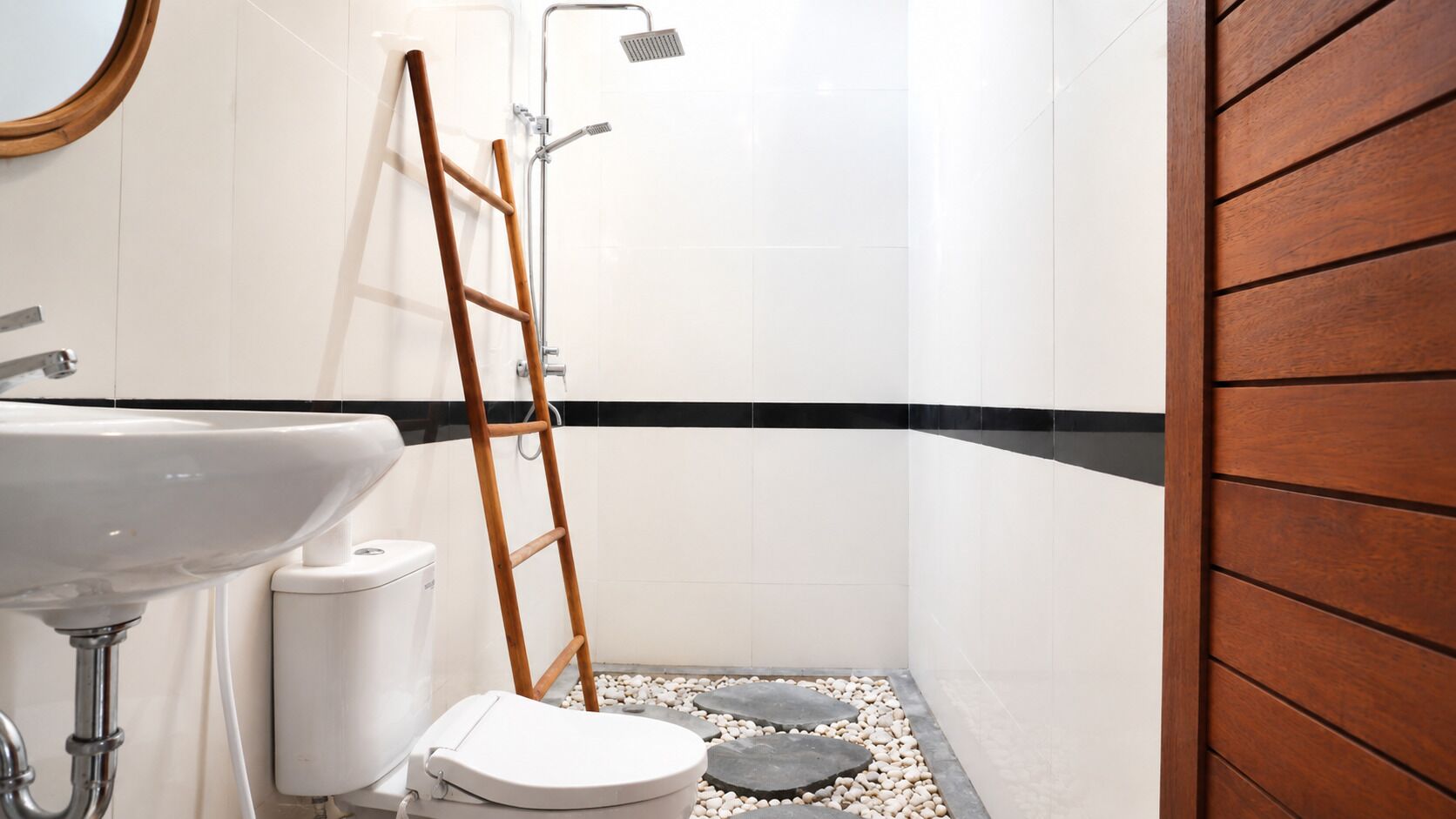 Un bagno con lavandino bianco, WC e zona doccia.