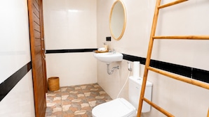A bathroom with a toilet, sink, and mirror. - Eka Wisnu 2BR Private Pool Villa by TVM (Ubud)