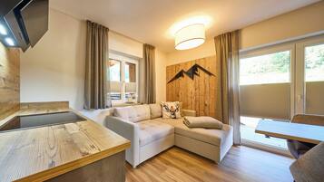 Un salon moderne avec un canapé, un mur d’accent en bois, un téléviseur à écran plat et un coin repas.