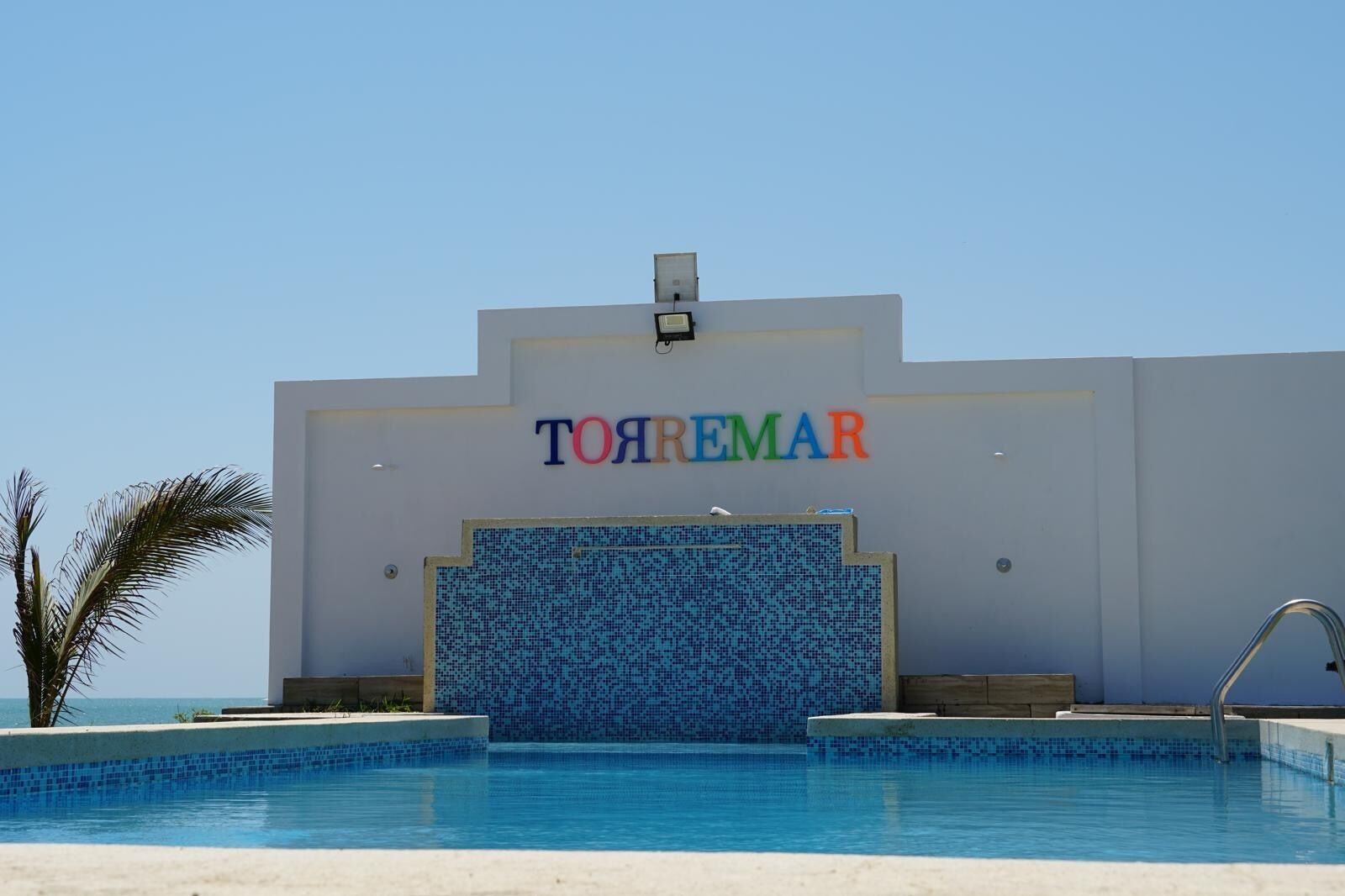 Un hotel llamado 'TOYREMAR' con piscina al frente.