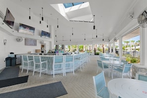 A modern bar area with high ceilings, pendant lighting, and a view of the outdoors. - Blue Island Getaway only 8 miles to Disney (Clermont)
