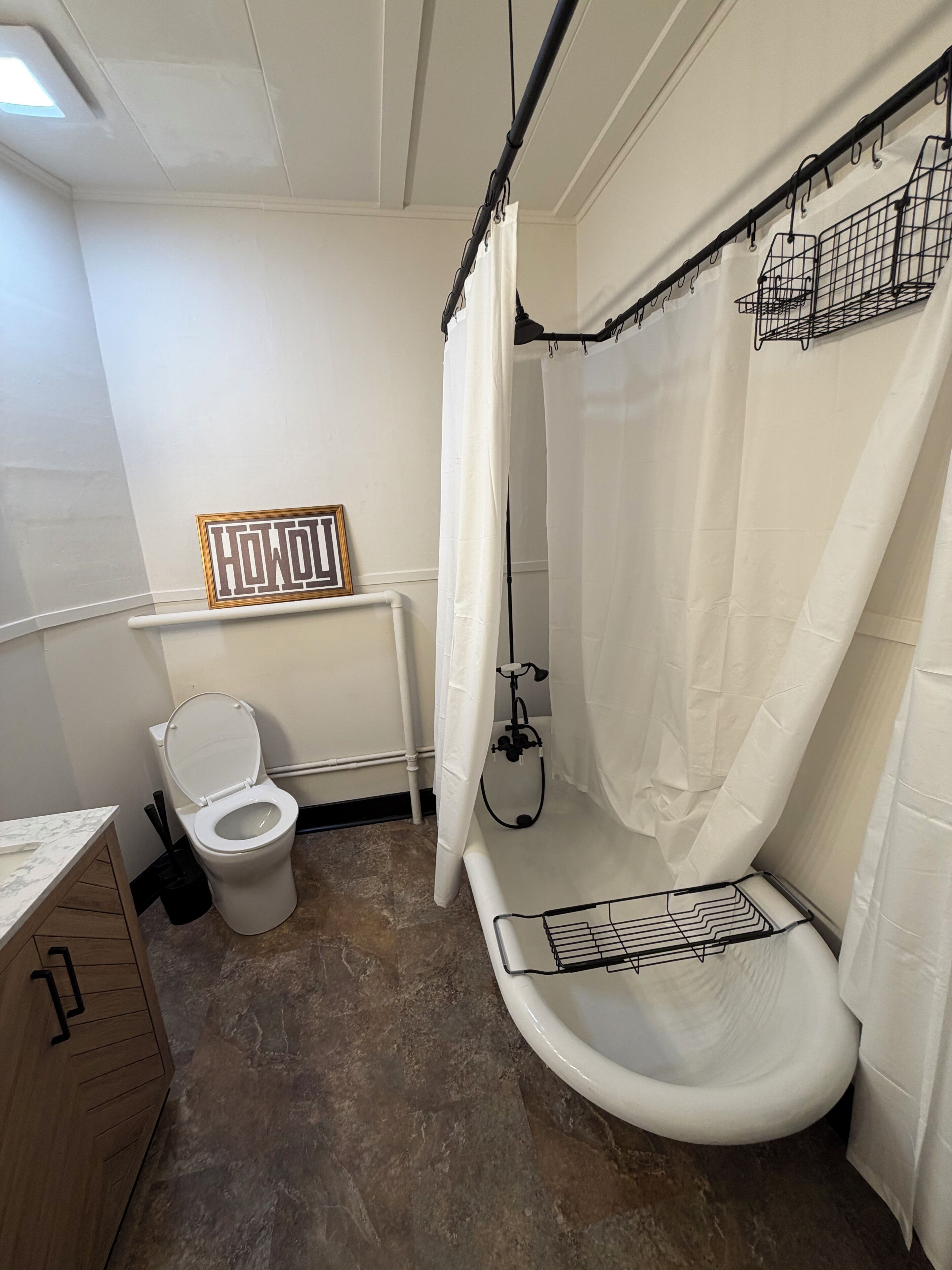A bathroom with a toilet, shower, and a towel rack.