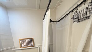 Et badeværelse med toilet, brusebad og et håndklædestativ.