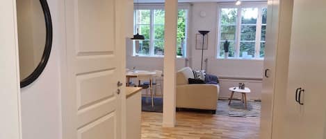 A hallway with a wooden floor, a white door, and a radiator.