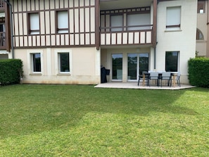 Ein zweistöckiges Wohngebäude mit Balkon und Terrassenbereich.