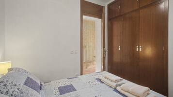 Un dormitorio con una cama, un armario y una puerta que da a un espacio exterior.